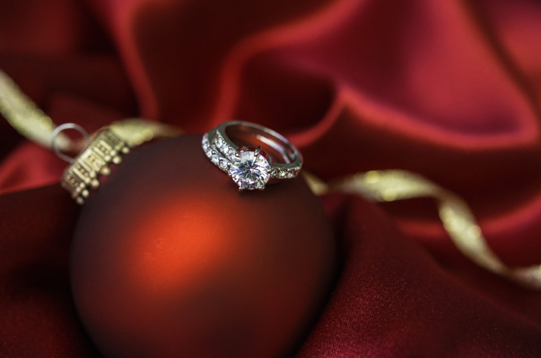 Christmas bauble with wedding and engagement rings in red satin